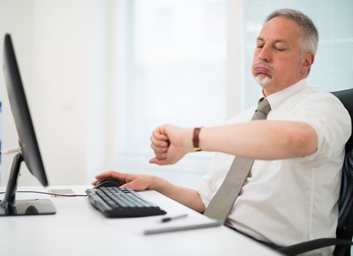 Impatient businessman watching his wrist watch in the office